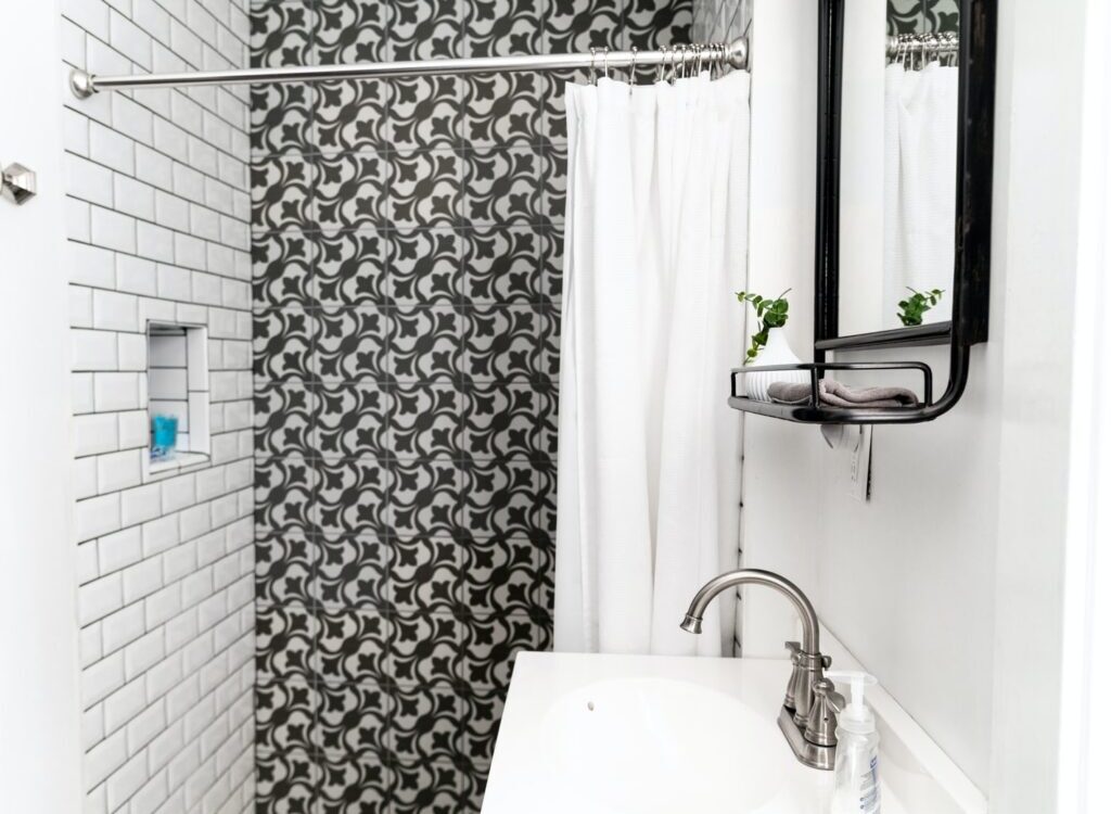 white ceramic sink beside white and gray floral shower curtain