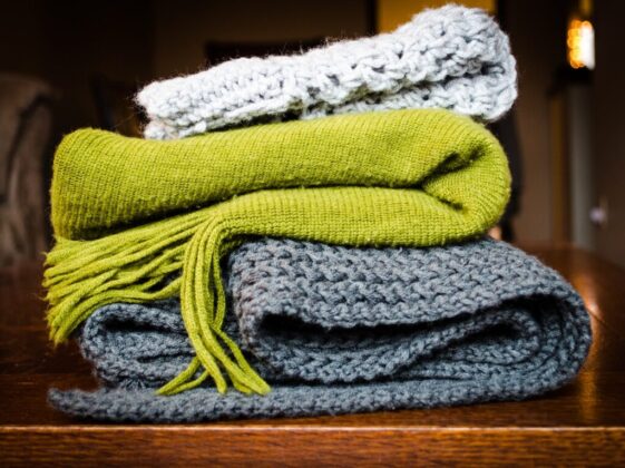 three gray, green, and white scarf on top of table