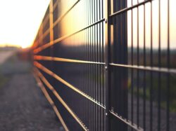 black metal fence during sunset